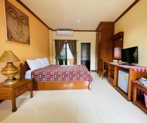 a hotel room with a bed and a television at Mini Cost Apartment&Guesthouse in Chiang Mai