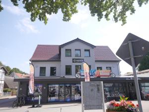 a white building with signs in front of it at Zur Eiche in Ahlbeck