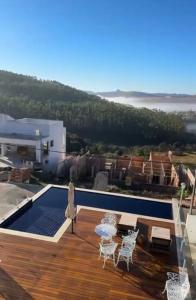 a villa with a swimming pool and a deck at MANSÃO Casablanca in Nova Lima