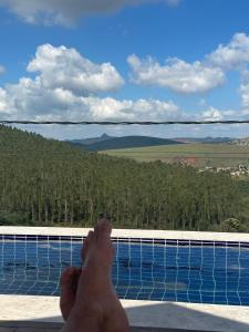 a persons feet on the ledge of a pool at MANSÃO Casablanca in Nova Lima +46 photos
