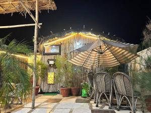 a patio with two chairs and an umbrella at 3BHK floor in urban homestay-swiming pool, Jacuzzi in Zirakpur