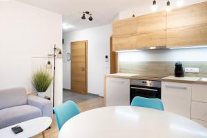 kuchnia z białym stołem i niebieskimi krzesłami w obiekcie Apartment SCHLADMING - Neualm center w Schladming