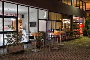 a restaurant with stools in front of a building at Hotel Valpolicella International in San Pietro in Cariano