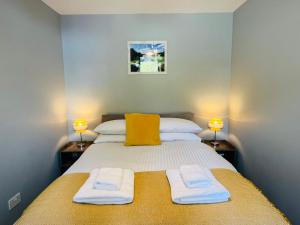 a bedroom with a bed with two towels on it at Marina Apartments 2 in Fort William
