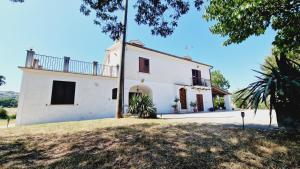 a white house with a balcony on the side of it at Country Chic Antico Casale - piscina idromassaggio lettini, solarium, cinema experience, wifi, parcheggio in Caiazzo +134 photos
