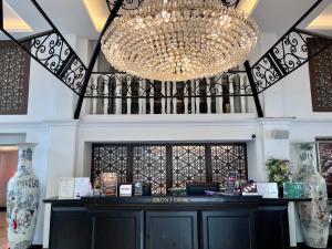un magasin avec un grand lustre au-dessus d'un comptoir dans l'établissement Siam Champs Elyseesi Unique Hotel, à Bangkok