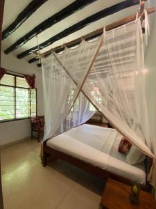 a bedroom with a bed with mosquito net at Mangrove Lodge in Zanzibar City +73 photos