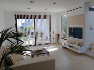 a living room with a couch and a tv at Villa Anastasia in Psinthos