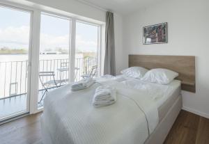 a bedroom with a white bed with towels on it at Fantastic studio w balcony - 326 in Odense