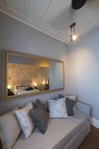 a living room with a couch and a mirror at Castellano Hotel & Suites in Nafplio
