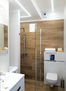 a bathroom with a toilet and a glass shower at APARTAMENT pod DĘBOWCEM in Bielsko-Biala