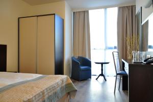 a hotel room with a bed and a desk and a chair at Hotel Burgas Free University in Burgas