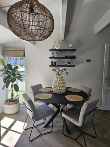 a dining room with a black table and chairs at Casa do Cervo, Boshof 6 Luxe met overdekt terras in Ermelo