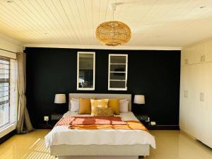 a bedroom with a large bed with a black wall at Round Robben in Langebaan