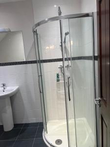 a shower with a glass door in a bathroom at Self contain studio with room, double bed, kitchen in London