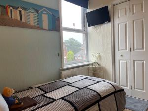 a bedroom with a bed and a window at Arun Sands Rooms in Littlehampton