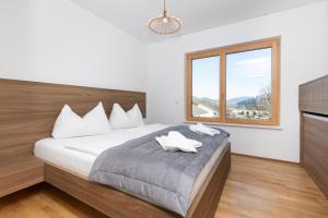 een slaapkamer met een groot bed met een raam bij Apartment SCHLADMING - Planai view in Schladming