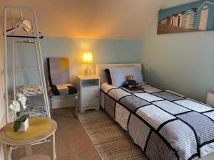 a bedroom with a bed with a ladder and a table at Arun Sands Rooms in Littlehampton