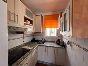 a kitchen with white cabinets and a sink at Seaside Paradise Mazagon in Mazagón