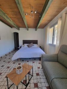a bedroom with a bed and a couch and a table at L'Oustau de Maître Potager in Valréas