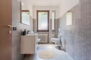 un baño con inodoro y lavabo en Harmony on the Lake by Rent All Como, en Argegno