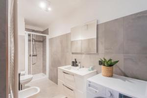 Un baño con lavabo, inodoro y ducha. en Harmony on the Lake by Rent All Como, en Argegno