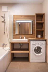 een badkamer met wastafel en wasmachine bij Apartment SCHLADMING - Planai view in Schladming