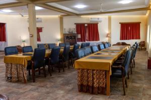 a conference room with long tables and chairs at Golden Hill Parker Hotel in Elmina +202 photos
