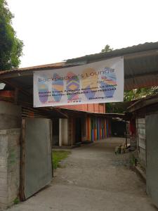 een spandoek dat aan het dak van een gebouw hangt bij Backpacker's Lodge - Fan Room 1 in Bacnotan +5 foto's