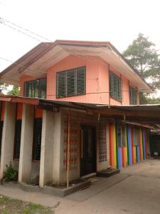 een kleurrijk huis met een regenboog bij Backpacker's Lodge - Fan Room 1 in Bacnotan