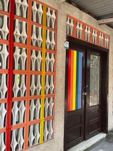 een gebouw met een kleurrijke deur en een raam bij Backpacker's Lodge - Fan Room 1 in Bacnotan
