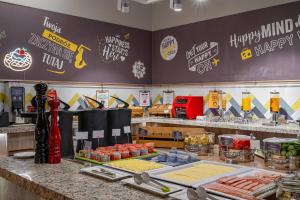 a restaurant with a counter with food on it at Hampton by Hilton Warsaw Airport in Warsaw