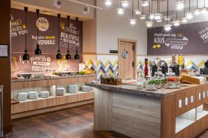 a restaurant with a counter with wine bottles at Hampton by Hilton Warsaw Airport in Warsaw
