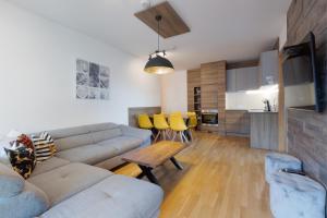 een woonkamer met een bank en een tafel bij Apartment SCHLADMING - Planai view in Schladming