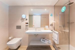 a bathroom with a sink and a toilet and a shower at Barceló Corralejo Sands in Corralejo