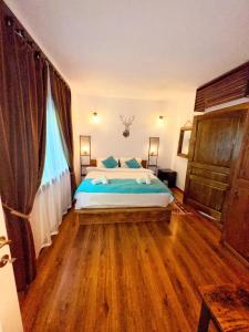 a bedroom with a large bed with blue pillows at Cabana Rose House in Borşa +40 photos