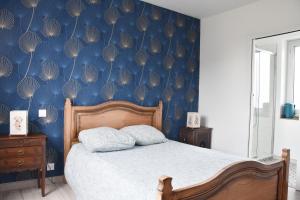 a bedroom with a bed with a blue wall at Le Presbytère du Talbert in Pleubian