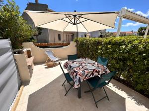a table and chairs with an umbrella on a patio at La pitchounette in Fleury