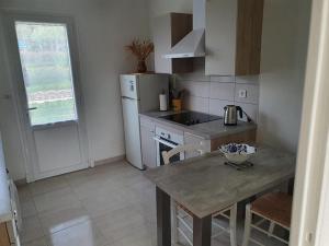 a kitchen with a table and a stove and a refrigerator at Le studio de claire à 700 m à pied de la plage in Bormes-les-Mimosas