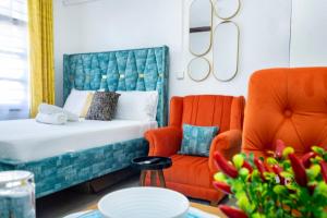 a bedroom with a bed and a chair and a table at Marahaba Cozy Studio Nyali in Mombasa