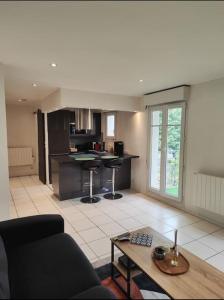 una sala de estar con un sofá y una mesa en Charming studio near from CDG airport, en Roissy-en-France