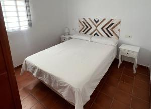 a bedroom with a large bed with white sheets at Seaside Paradise Mazagon in Mazagón