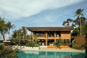 a resort with a swimming pool in front of a building at Barcelo Coconut Island, Phuket in Phuket Town