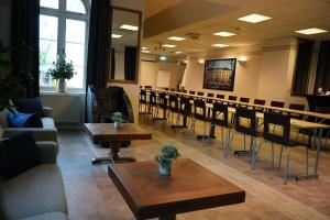 a waiting room with tables and chairs in a room at Vänerport Stadshotell i Mariestad in Mariestad