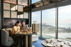 a man and woman sitting at a table in a room with windows at Marina Bay Sands in Singapore