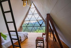 a bedroom with a loft bed and a large window at Eco Vibe Resort in Rattota