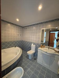 a bathroom with a tub and a toilet and a sink at Casa Beatriz in Cambados +11 photos