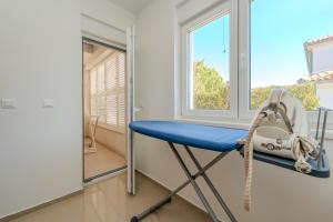 una silla azul en una habitación con ventana en New Luxury Villa "Via", en Zadar
