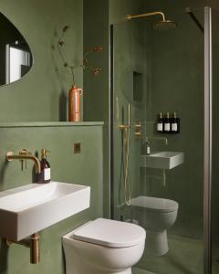 une salle de bain avec un lavabo, des toilettes et une douche dans l'établissement Yarn - Romy Deluxe Apartment, à Ballycastle
