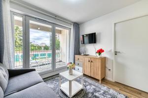 ein Wohnzimmer mit Sofa und Fernseher in der Unterkunft Moulin à Vent A14 - Appt pour 4 avec balcon in Bondy
